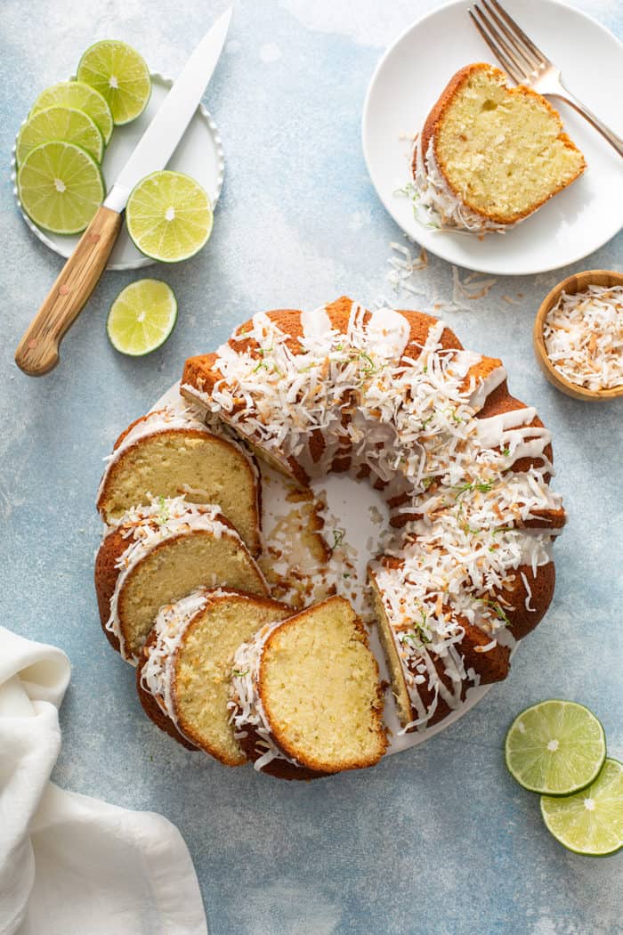 Sliced lime coconut cake surrounded by sliced limes