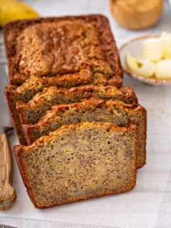 Sliced loaf of zucchini banana bread on a piece of parchment paper
