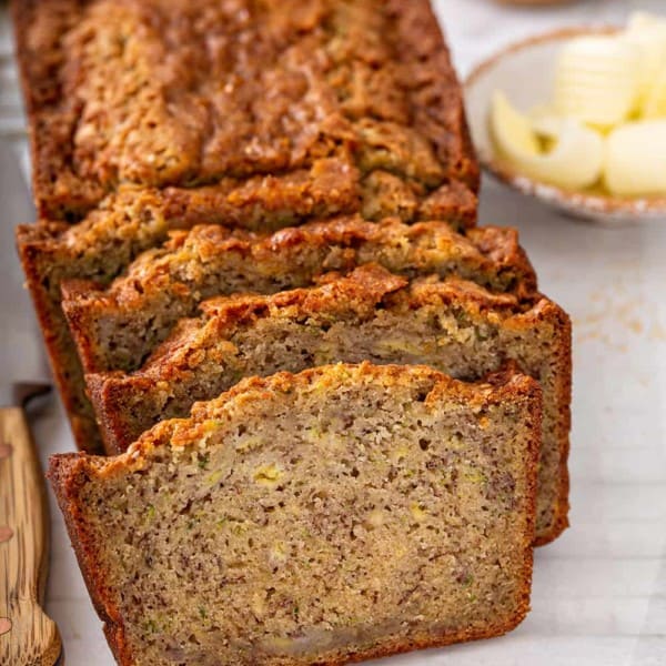 Sliced loaf of zucchini banana bread on a piece of parchment paper