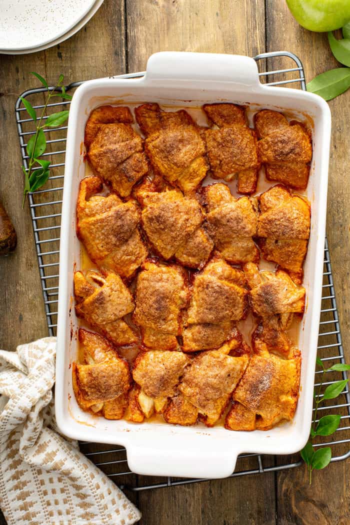 Baked easy apple dumplings in a white baking dish, set on a wire cooling rack