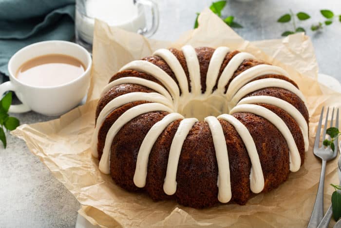 Frosted zucchini bundt cake set on a piece of parchment paper