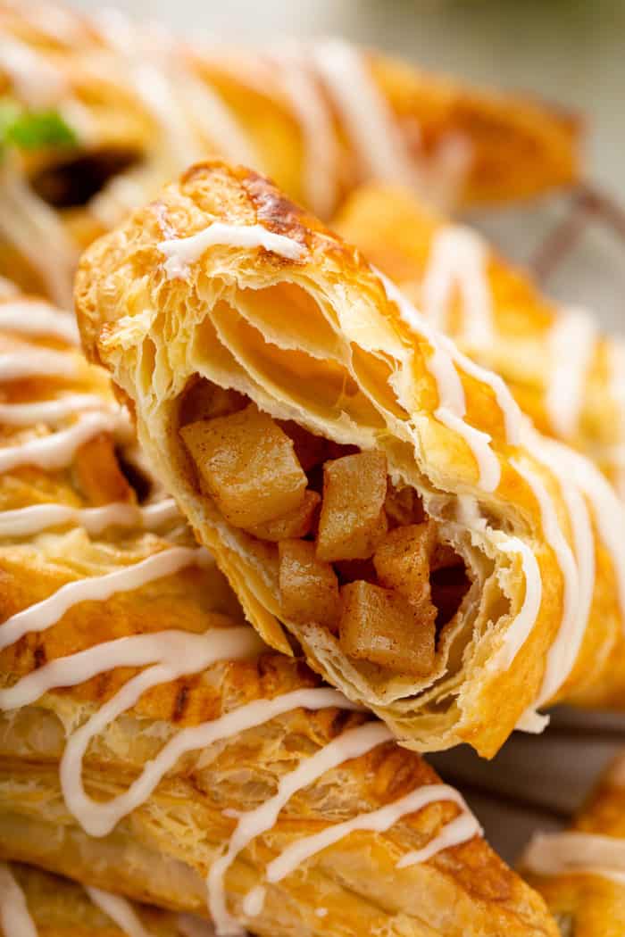 Close up of an apple turnover that has been cut in half to show the filling inside