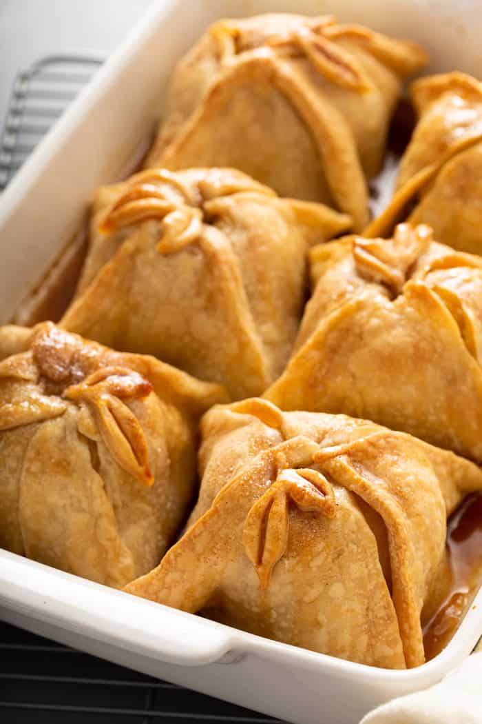 Close up of baked old-fashioned apple dumplings in a white baking dish