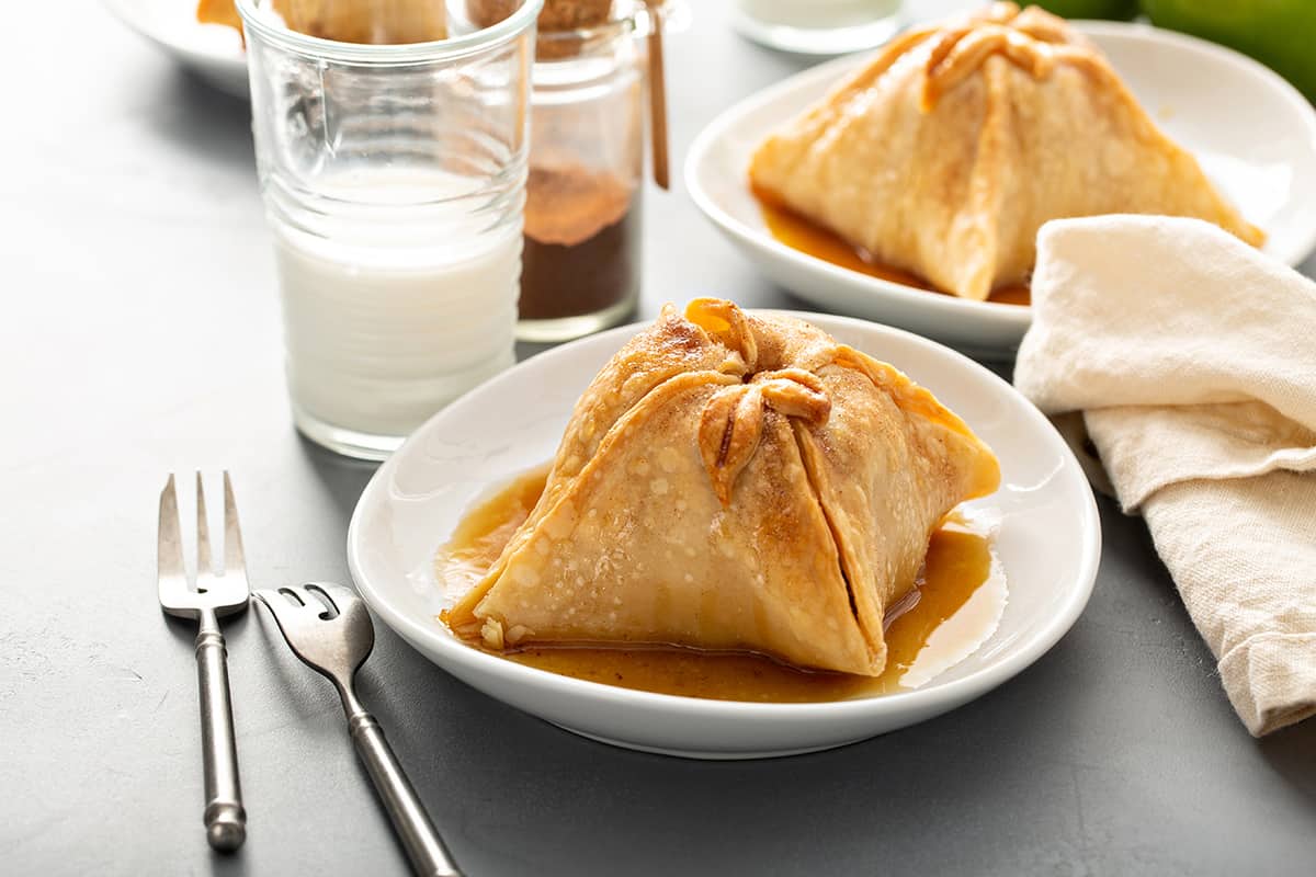 Plated old-fashioned apple dumpling with more apple dumplings in the background