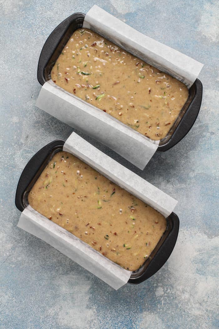Zucchini bread batter divided between two loaf pans, ready to bake