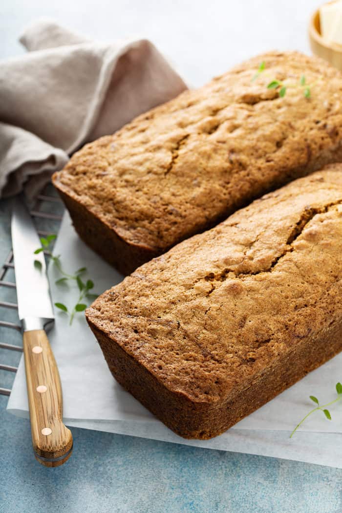 Two baked loaves of classic zucchini bread on a cutting board