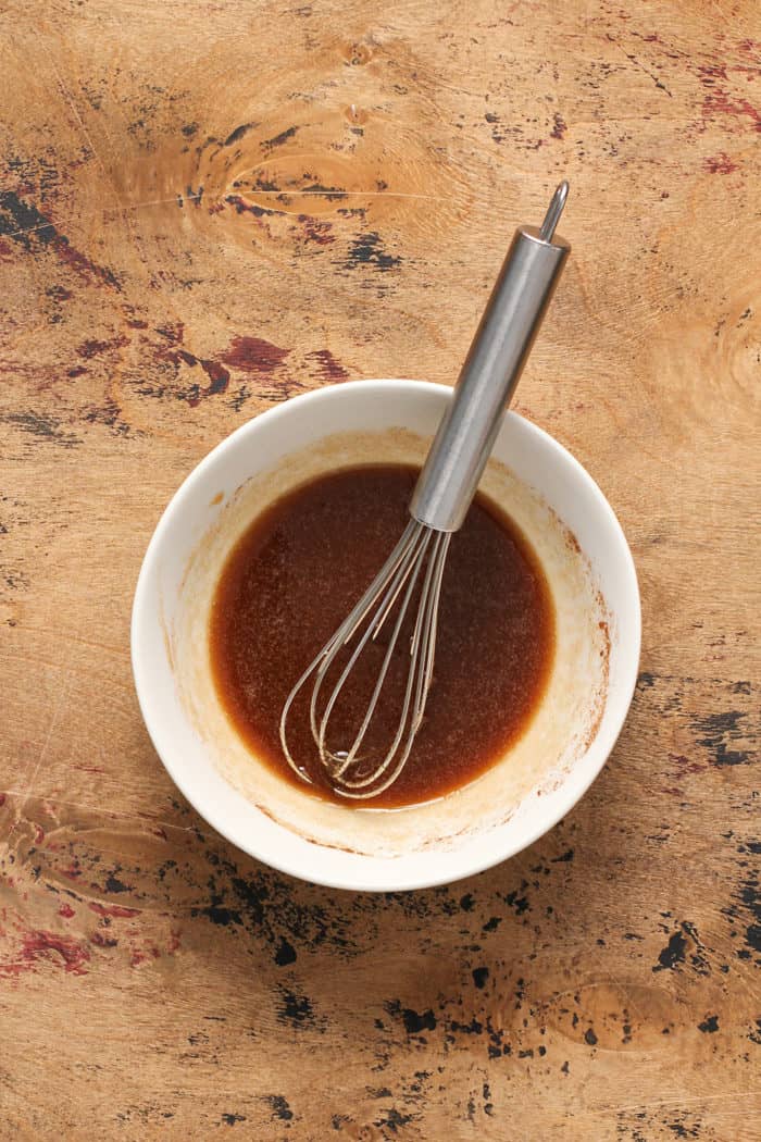 Whisk combining brown sugar glaze in a small white bowl