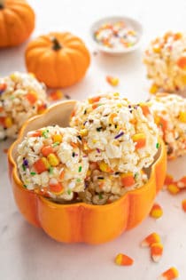 Pumpkin-shaped bowl filled with halloween popcorn balls