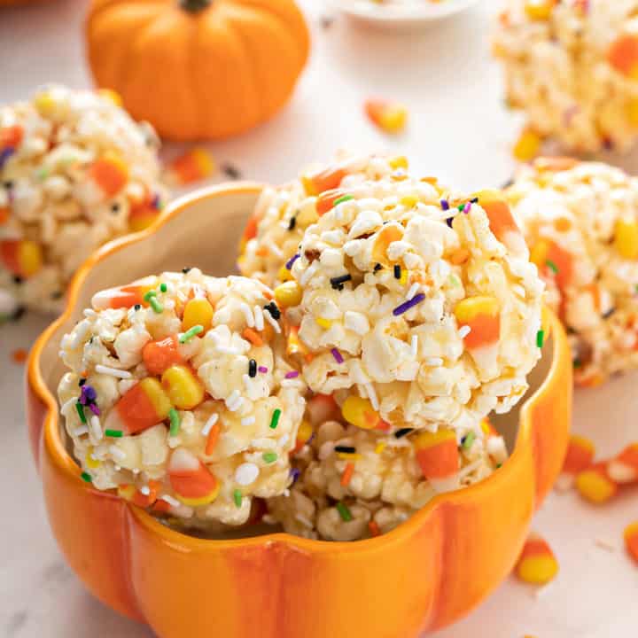 Pumpkin-shaped bowl filled with halloween popcorn balls