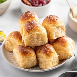 Plate filled with cheddar dinner rolls set on a dinner table