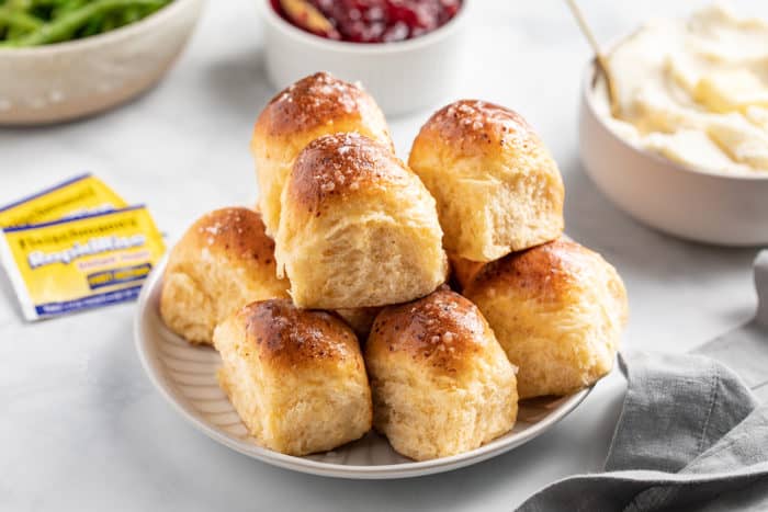 Plate filled with cheddar dinner rolls set on a dinner table