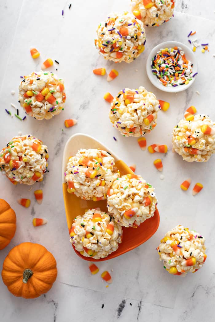 Overhead view of halloween popcorn balls arranged on a candy-corn-shaped plate