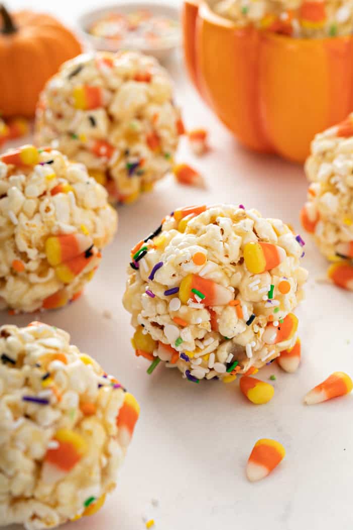 Close up of Halloween popcorn balls scattered on a marble countertop