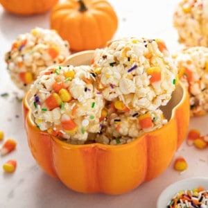 Halloween popcorn balls arranged in a pumpkin-shaped bowl