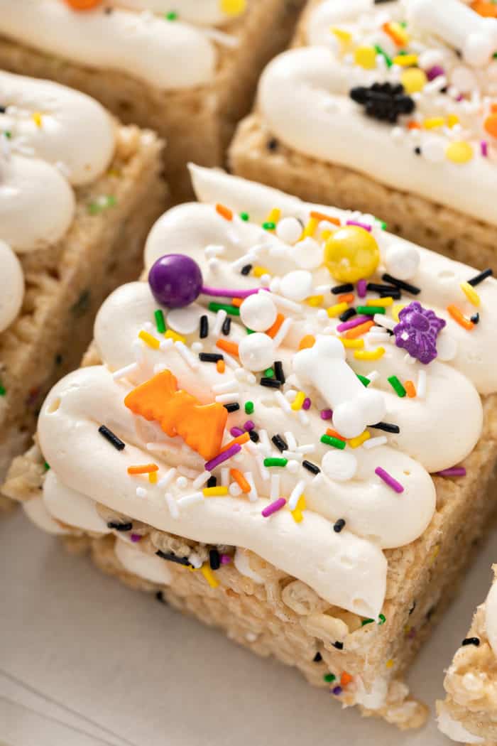 Close up of frosting halloween rice krispie treats topped with halloween sprinkles