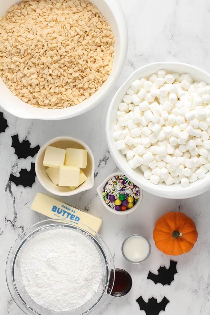 Ingredients for Halloween rice krispie treats arranged on a marble counter