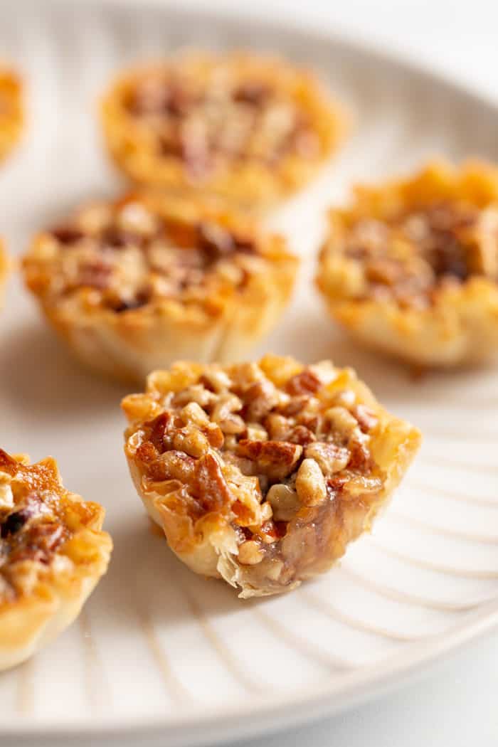 Close up of a cross section of a mini pecan pie, showing the gooey filling