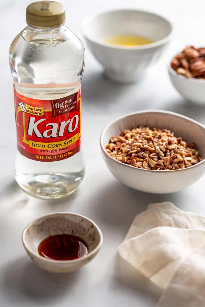 Mini pecan pie filling ingredients arranged on a white countertop