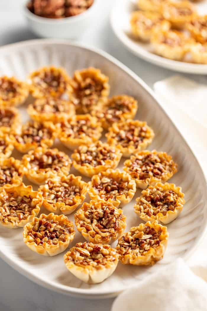 White platter filled with mini pecan pies set on a white countertop
