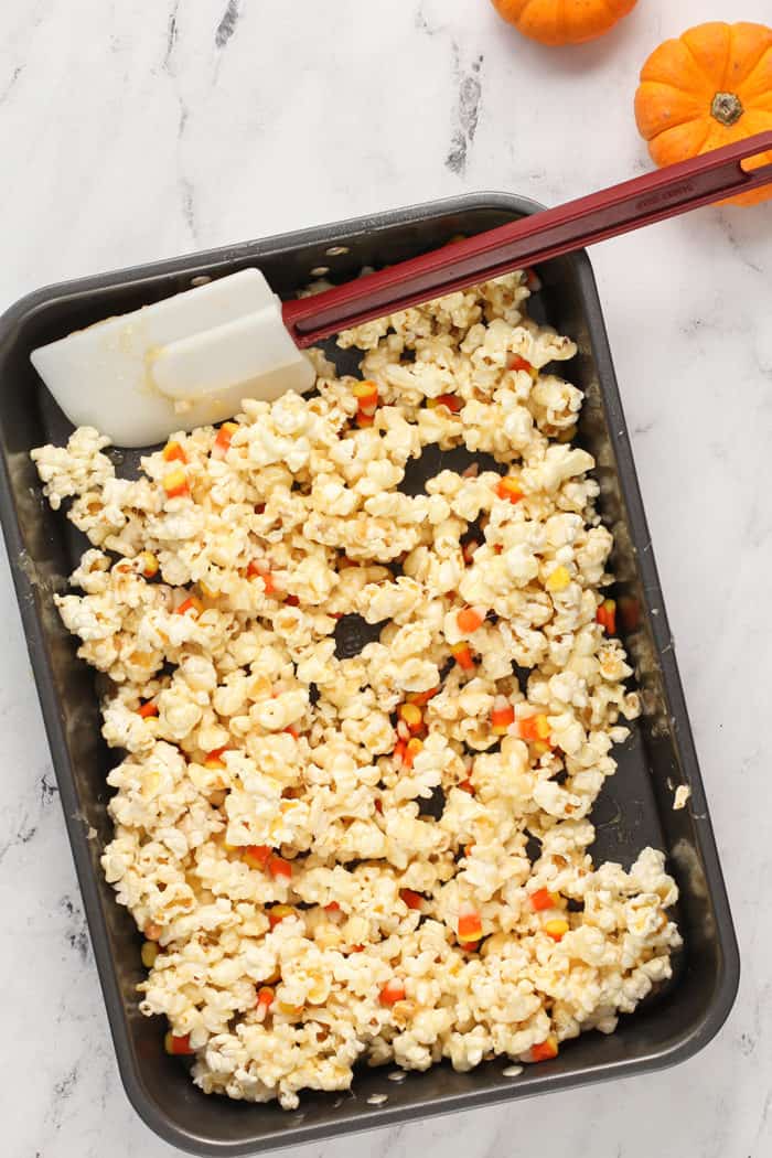 Spatula stirring together the ingredients for halloween popcorn balls