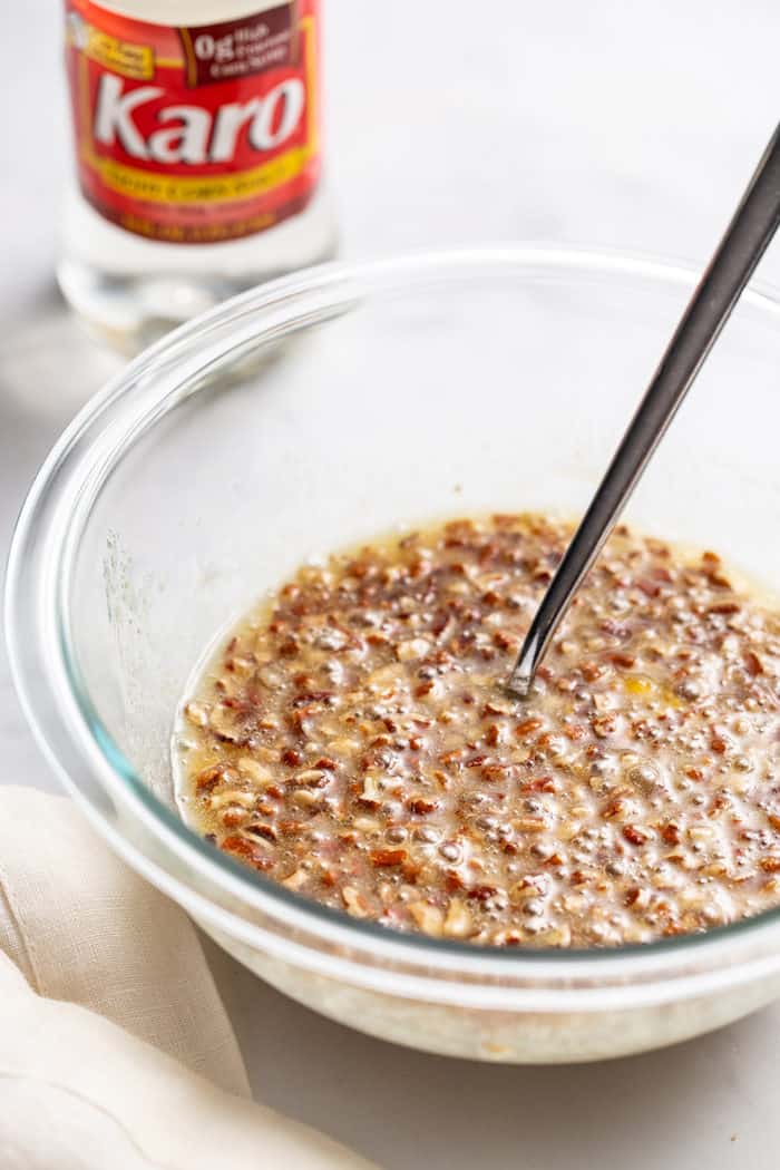 Pecan pie filling being stirred in a glass mixing bowl