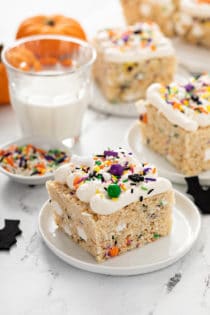 Plated halloween rice krispie treats next to a glass of milk