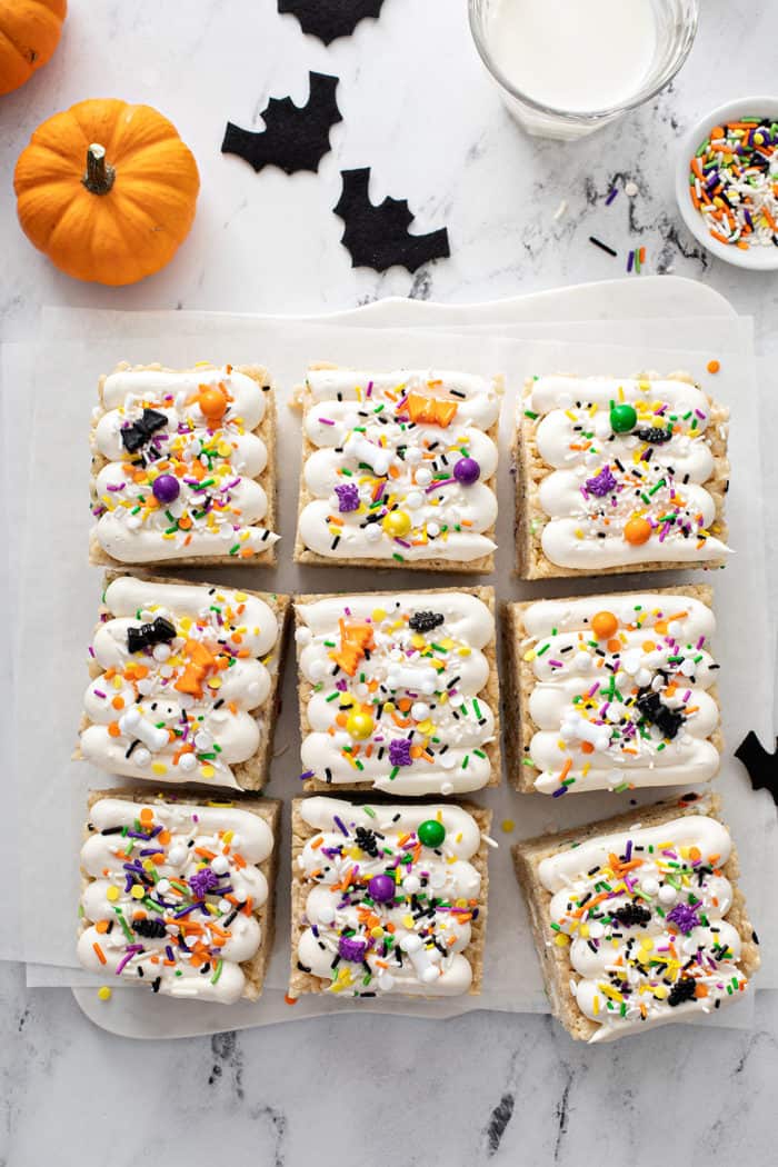 Overhead view of sliced and frosted halloween rice krispie treats on a piece of parchment paper