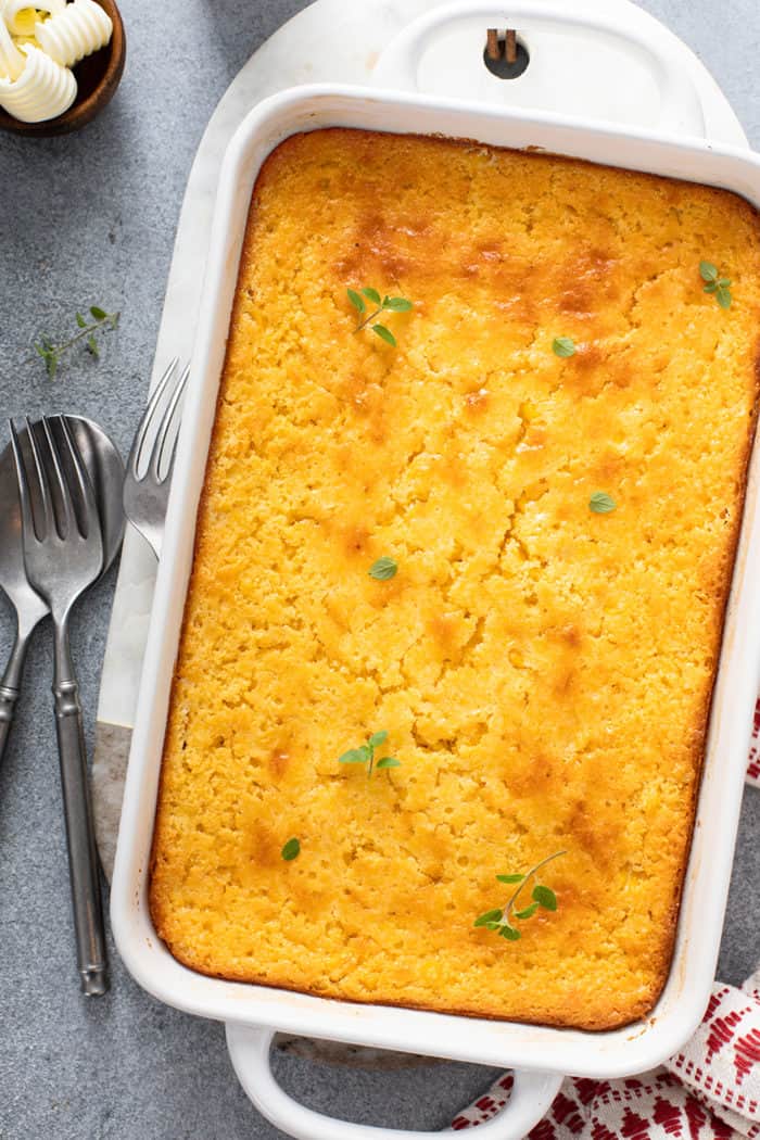 Baked jiffy corn casserole in a white baking dish, set on a gray countertop