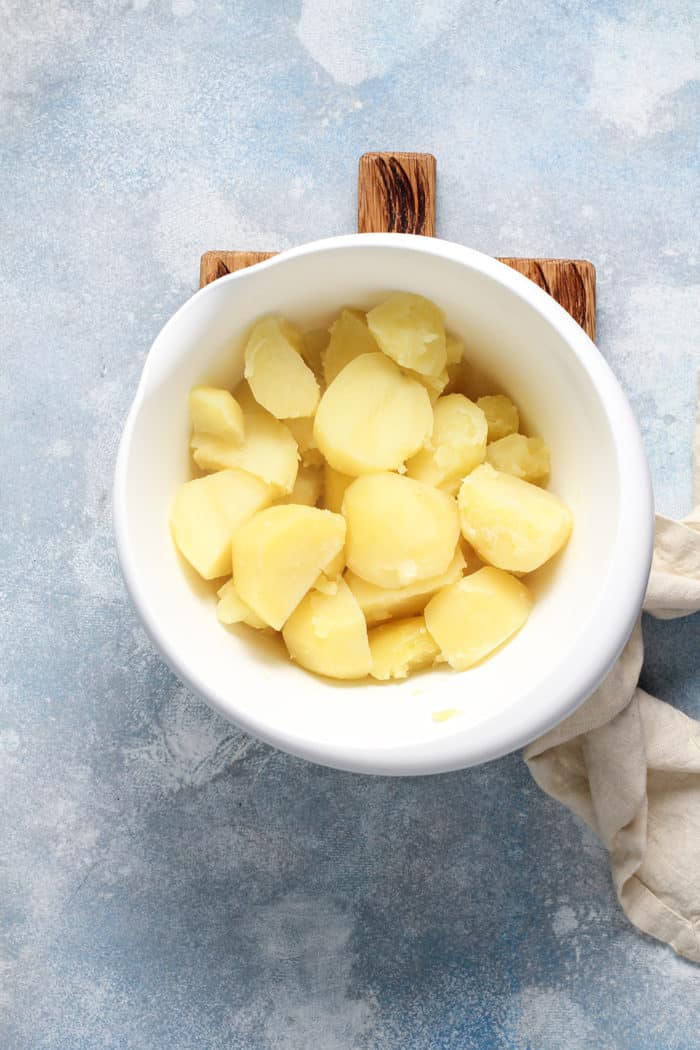 Cooked potatoes in a white mixing bowl