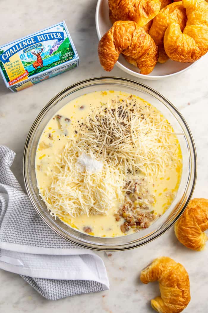 Beaten eggs, milk, cheese, and mushroom filling in a large glass mixing bowl