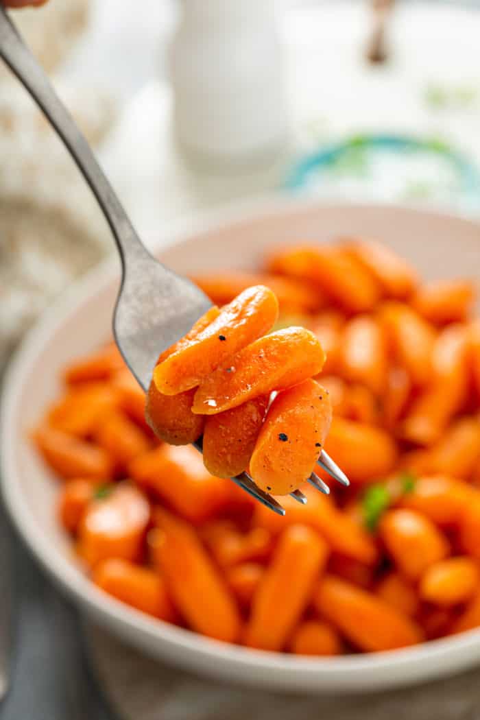 Close up of fork holding honey glazed carrots