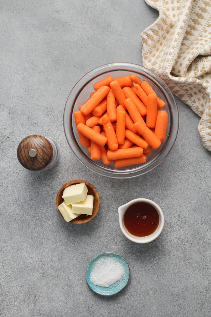 Ingredients for honey glazed carrots on a gray countertop