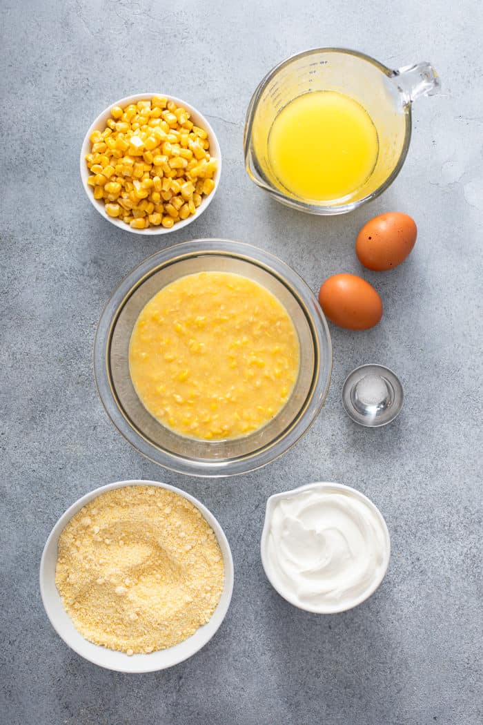 Ingredients for jiffy corn casserole arranged on a gray countertop