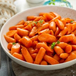 Bowl of honey glazed carrots garnished with fresh thyme