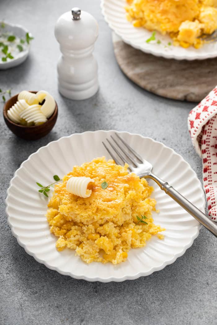 Portion of jiffy corn casserole and a fork set on a white plate