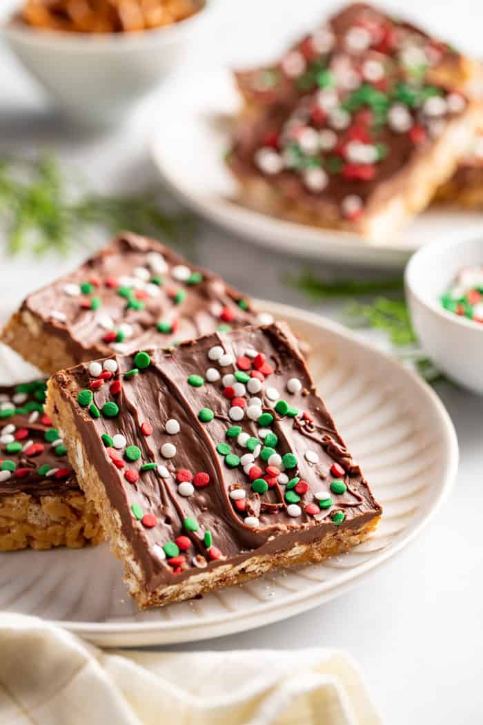 Plates of peanut butter pretzel bars topped with red and green sprinkles