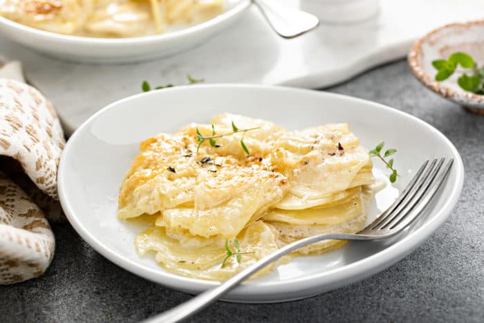 Fork alongside a serving of potato gratin on a white plate