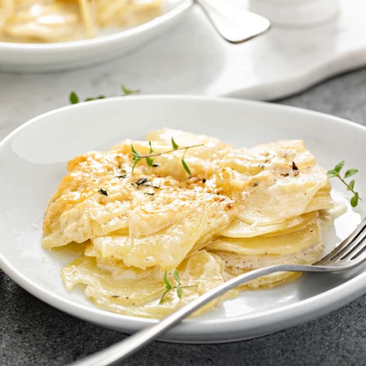 Fork alongside a serving of potato gratin on a white plate