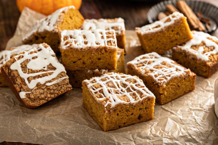 Pieces of pumpkin coffee cake arranged on a piece of parchment paper