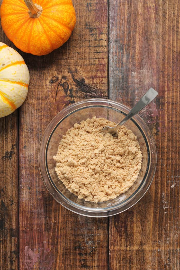 Bowl of streusel topping set on a wooden table