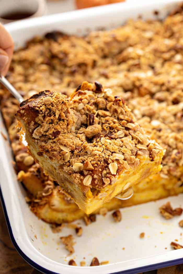 Piece of pumpkin french toast casserole being lifted out of a baking dish