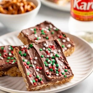 Three peanut butter pretzel bars on a white plate