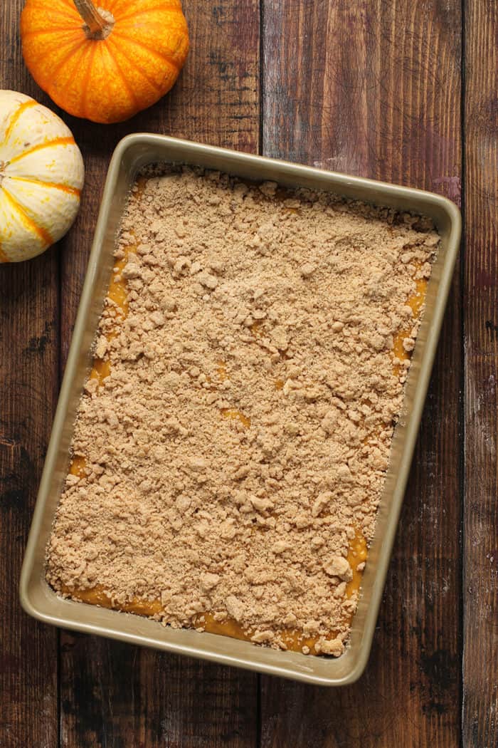 Streusel-topped pumpkin coffee cake ready to be baked in a metal cake pan