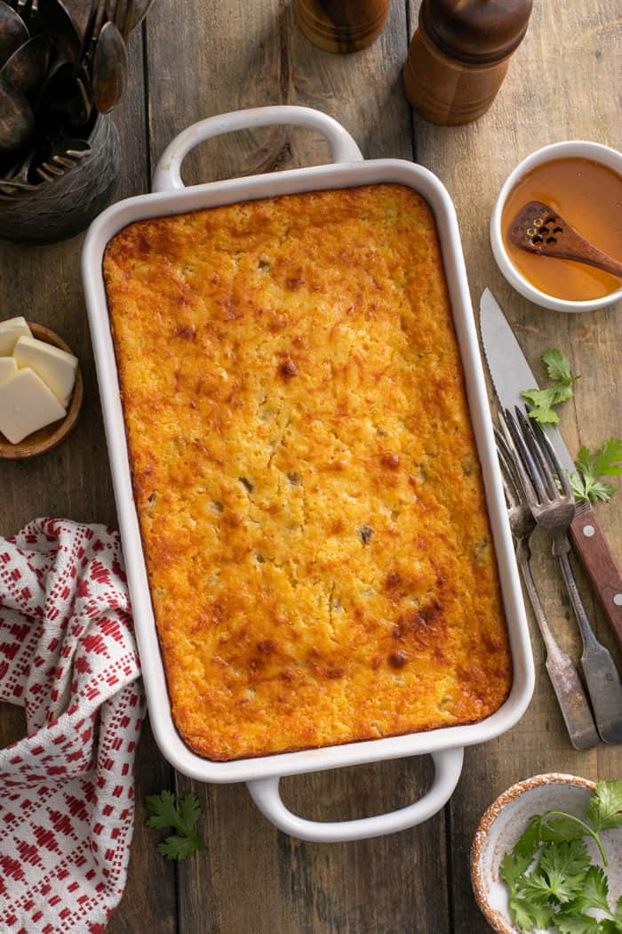 Overhead view of baked green chile corn casserole in a white baking dish