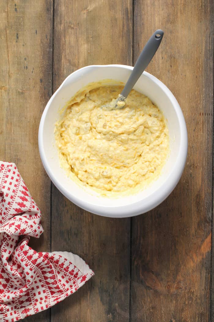 Batter for green chile corn casserole in a white mixing bowl