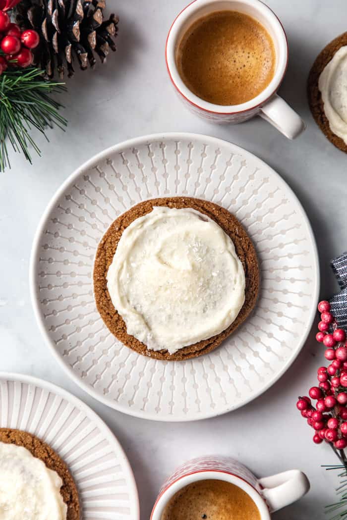 Close up of a big frosted ginger cookie on a white plate