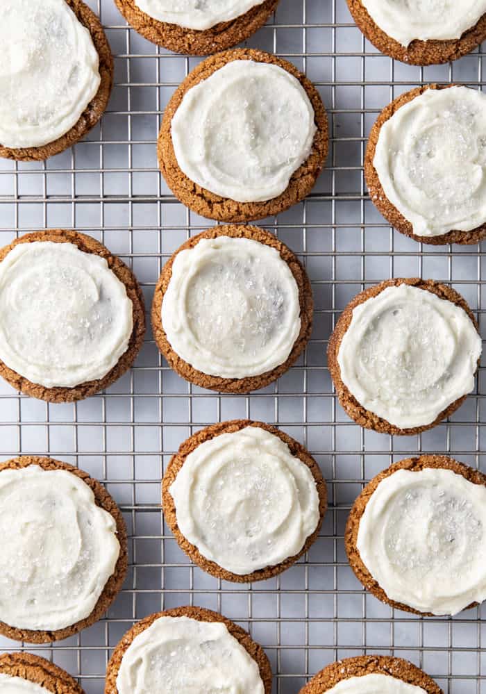 Frosted ginger cookies lined up on a wire rack