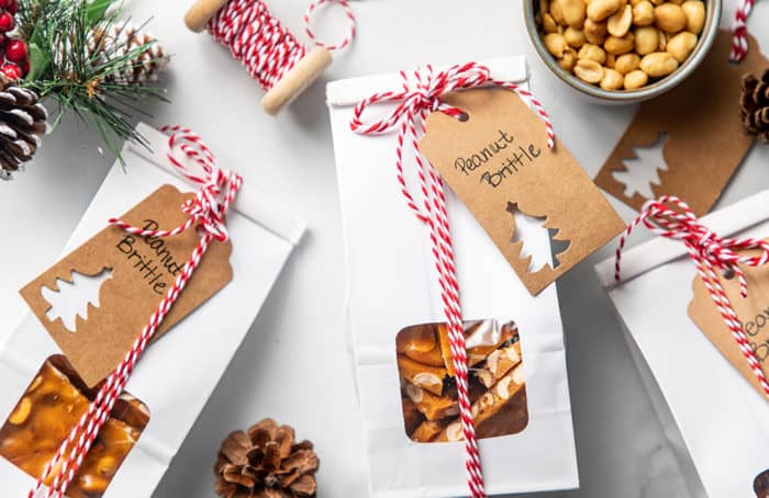 Several twine-tied packages of peanut brittle, tagged and ready for gifting