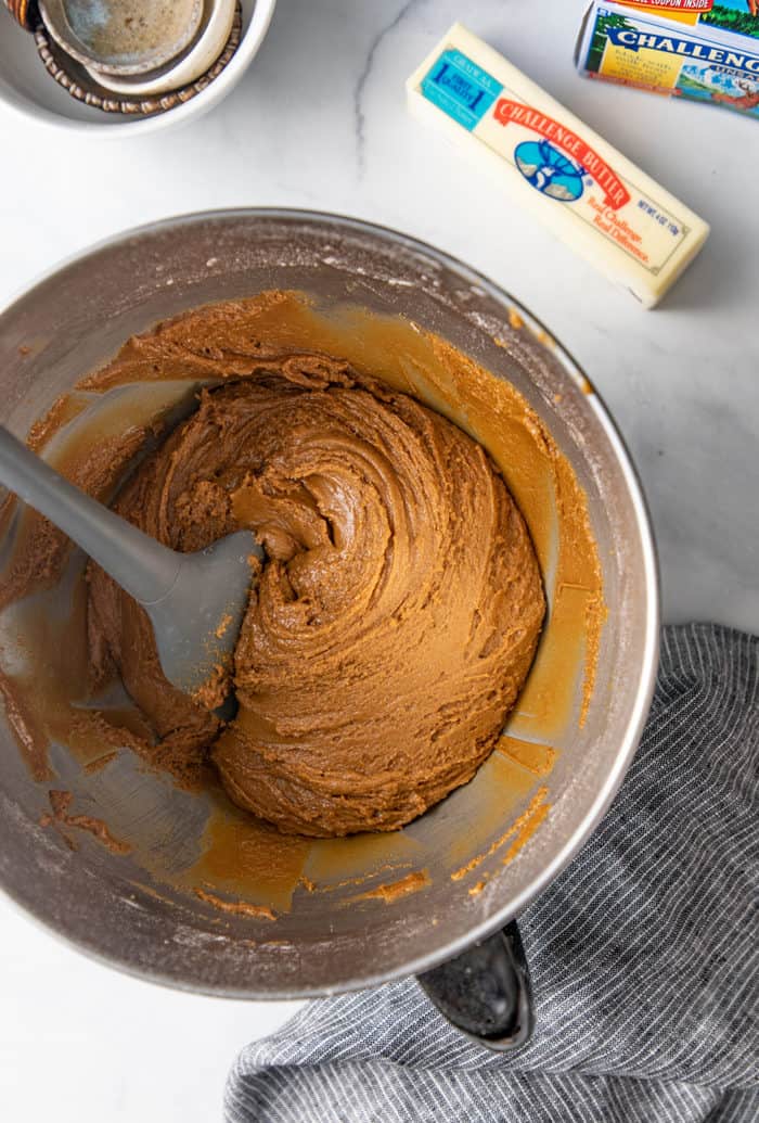 Spatula stirring ginger cookie dough in a metal bowl