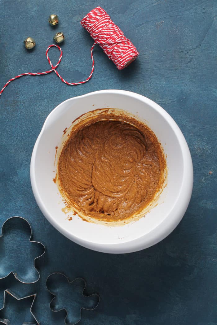 Gingerbread cookie wet ingredients combined in a white mixing bowl